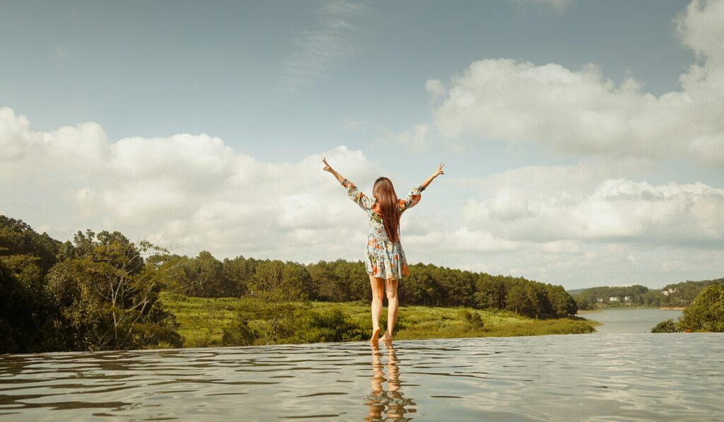 Woman in red and white plaid shirt and white shorts standing on water during daytime