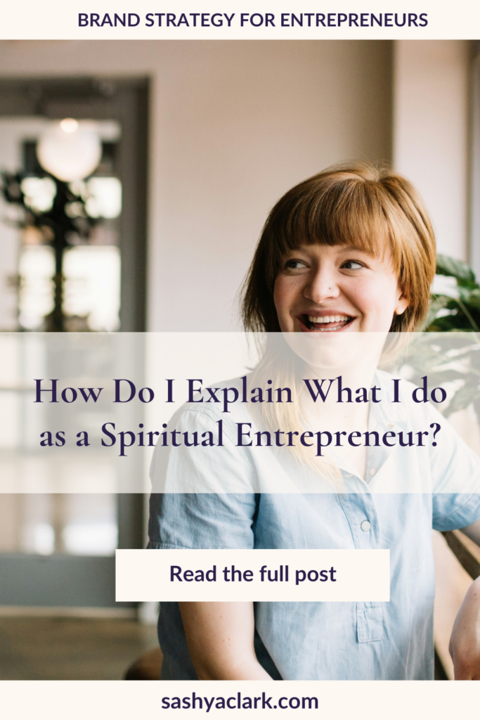 A smiling Woman with red hair and a light blue linen shirt with the caption that says, "How do I explain what I do as a Spiritual Entrepreneur by Sashya Clark Brand Strategist" 